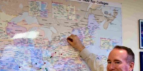 Man holding a pin on a map