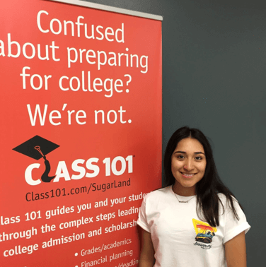 Student beside class 101 banner